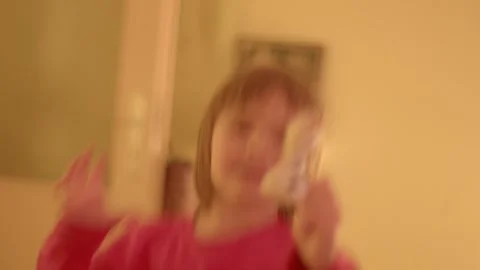 An animated young child eagerly shares toy with radiant smile Видео 334118249