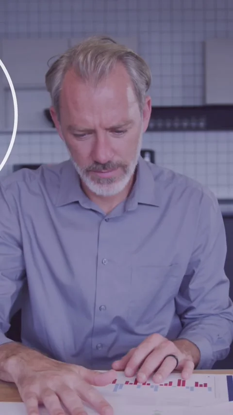 Animation of ai bot icon against thoughtful caucasian man reading a document at Stock Footage 344595766