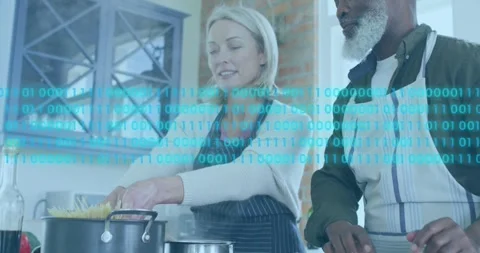 Animation of binary codes over diverse senior couple together cooking pasta in Stock Footage 252965782