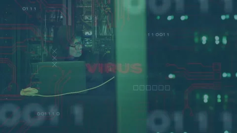 Animation of binary coding and virus text over asian male hacker using laptop in Stock Footage 303951025