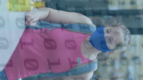 Animation of binary coding over caucasian woman with face mask disinfecting Stock Footage 313330639