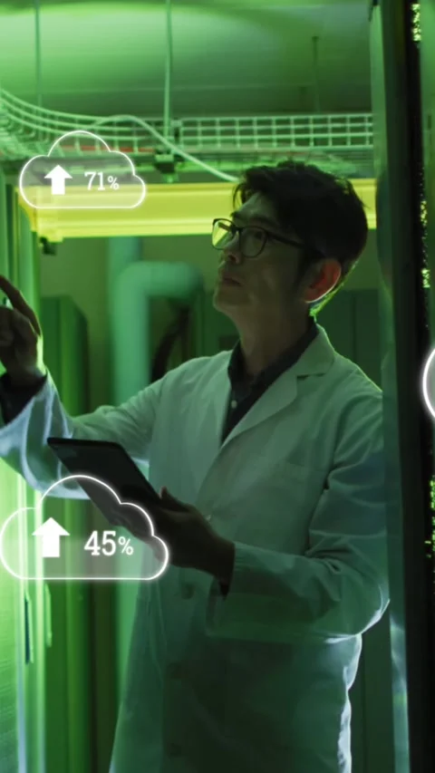 Animation of clouds with uploading over asian man working in server room Stock Footage 342594079