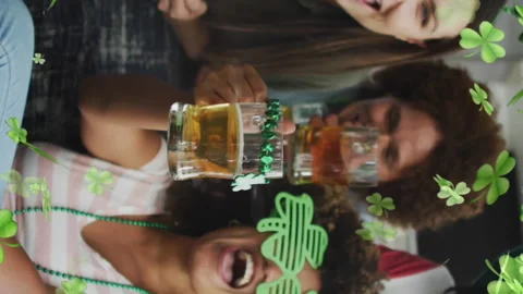 Animation of clover icons over diverse friends drinking beer Stock Footage 312532828