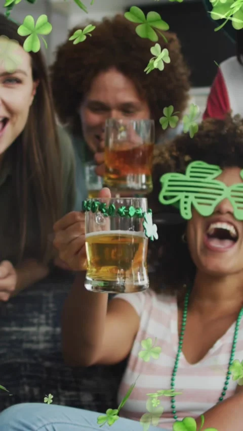 Animation of clover icons over diverse friends drinking beer Stock Footage 323909710