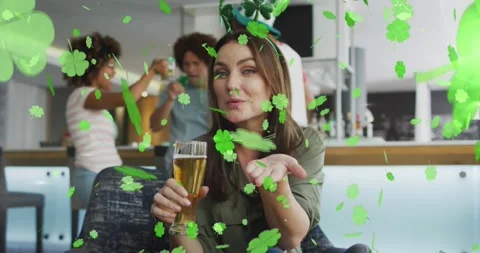 Animation of clover icons over diverse friends drinking beer Stock Footage 328450133