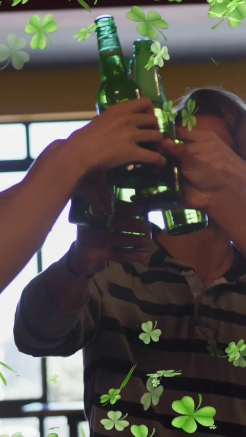 Animation of clover icons over diverse group of friends drinking beer 動画素材 343498666