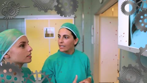 Animation of cogs moving over diverse female surgeons in hospital Stock Footage 327956445