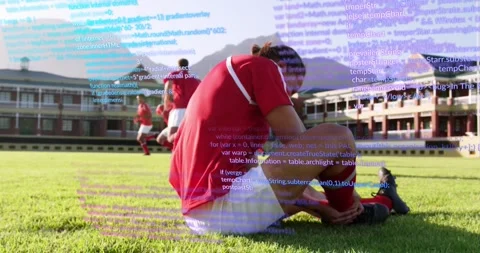 Animation of computer language over caucasian soccer player lying on ground in Stock Footage 329923074