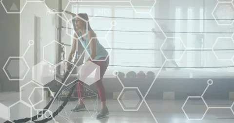Animation of data processing over caucasian woman exercising with ropes in gym Stock Footage 328811768