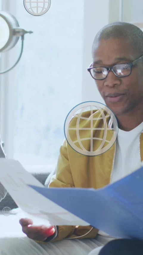 Animation of digital globe icons over diverse business people in office Stock Footage 344369553