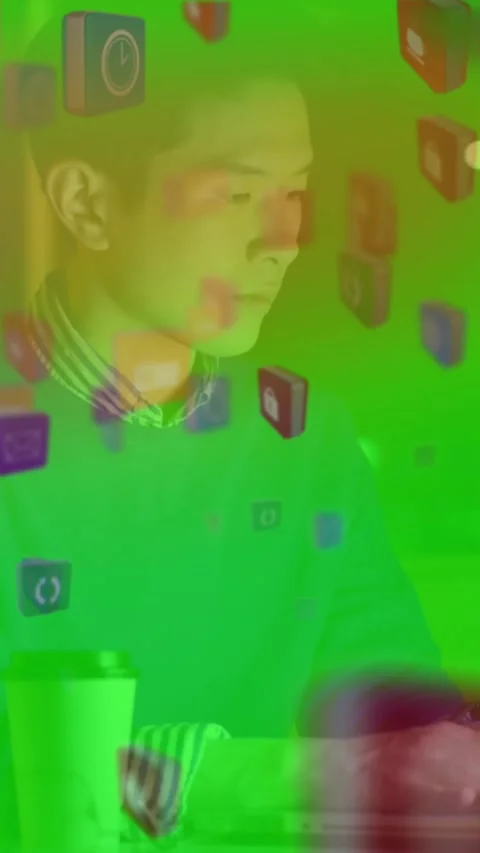 Animation of digital icons floating against asian businessman using laptop at Stock Footage 344774648