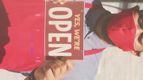 Animation of digital interface over man in face mask holding open sign Video stock 312384972