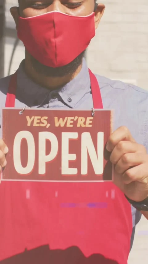 Animation of digital interface over man in face mask holding open sign Video stock 324432765