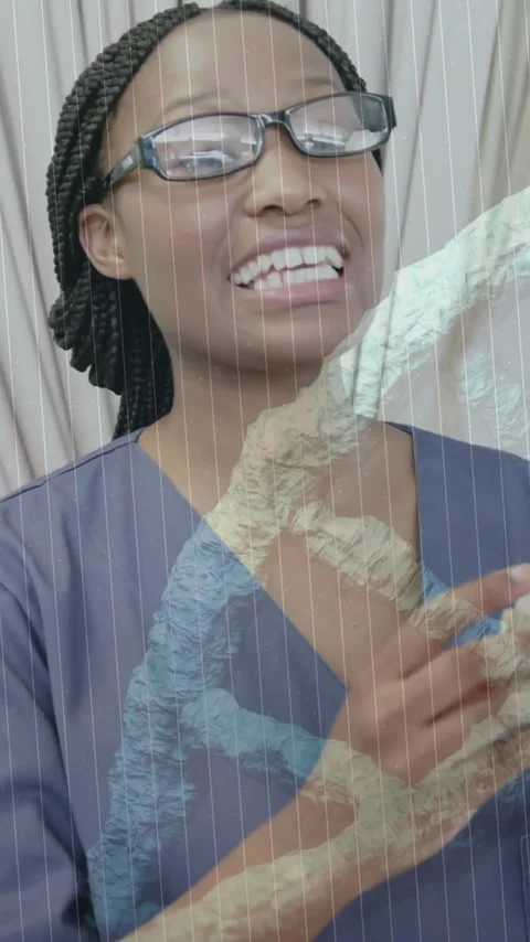 Animation of dna strand over african american female doctor fitting hearing aid 動画素材 323782815