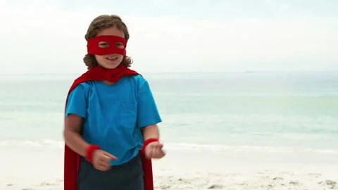 Animation of do it for them over happy caucasian boy in superhero mask on beach Stock Footage 329917337