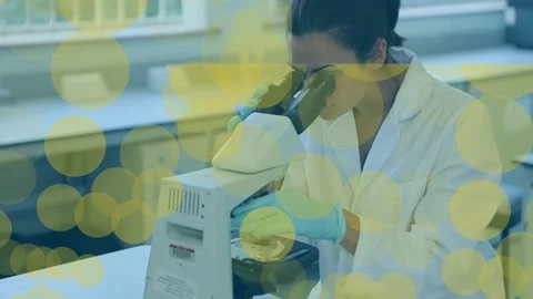 Animation of dots floating over female lab worker using microscope Stock Footage 329361577