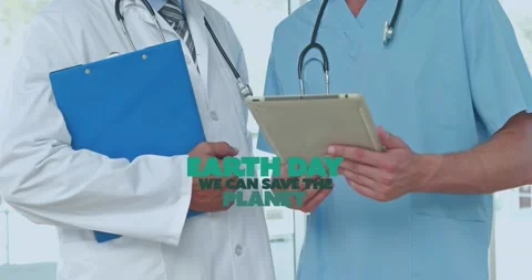 Animation of earth day text over caucasian doctors using tablet Stock Footage 327847607