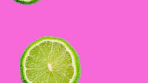 Animation of falling lime slices on a bright pink background Stock Footage 200187057