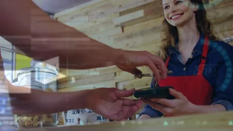 Animation of financial data processing over caucasian woman paying at payment Stock Footage 220378612