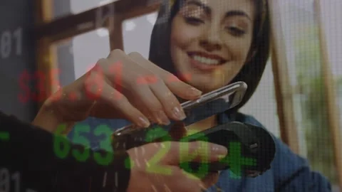 Animation of financial data processing over caucasian woman paying at payment Stock Footage 329026337