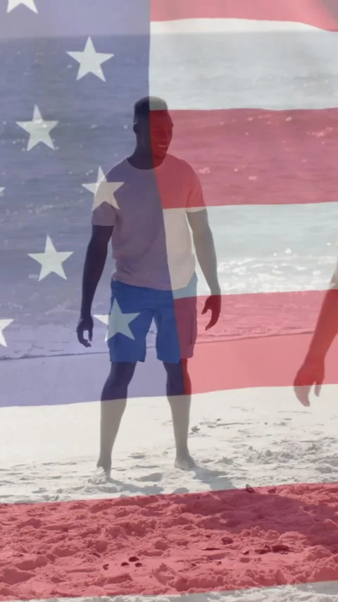 Animation of flag of usa over diverse friends playing football on beach Stock Footage 343079128