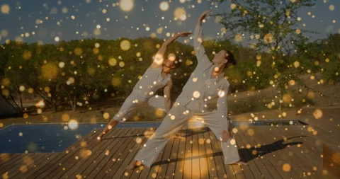 Animation of floating light spots over caucasian couple practicing yoga Stock Footage 308841346