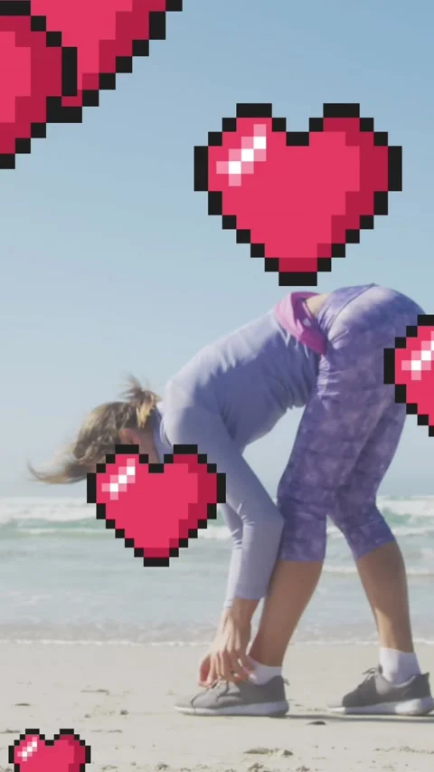 Animation of floating red pixel hearts, over woman tying shoe on beach Stock Footage 341952927