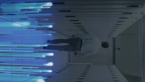 Animation of glowing blue light trails over rear view of male engineer walking Stock Footage 312390167