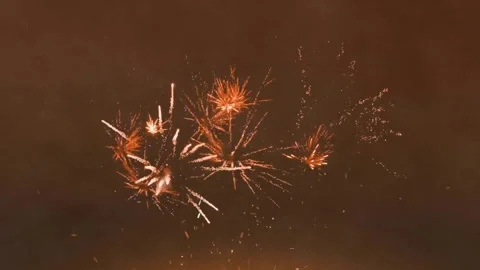 Animation of glowing fireworks exploding over brown background Stock Footage 330591259