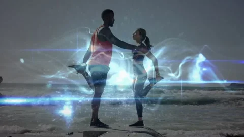 Animation of glowing light over couple exercising on beach Stock Footage 329361061