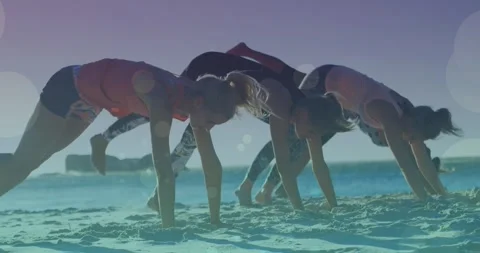 Animation of glowing lights over group of female friends exercising by the sea Stock Footage 328641525
