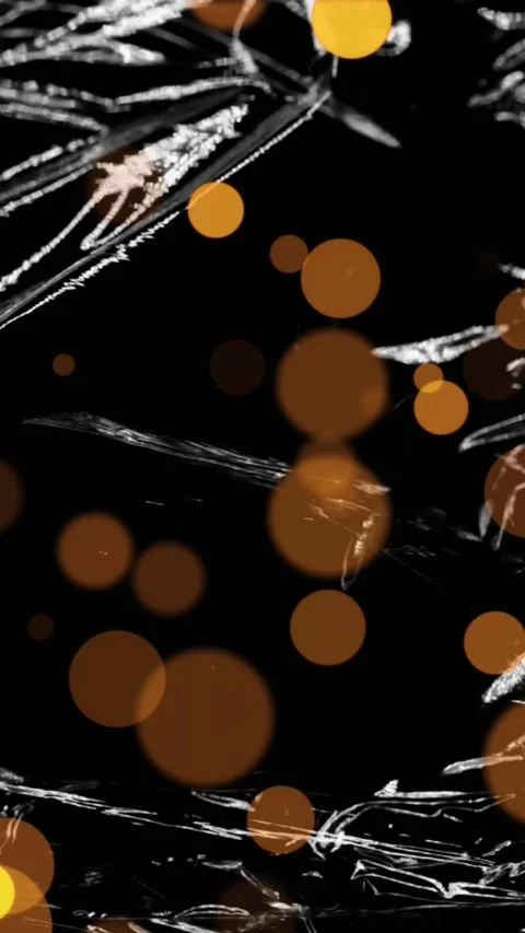 Animation of gold spots of light over light on moving shiny black plastic Stock Footage 323922454