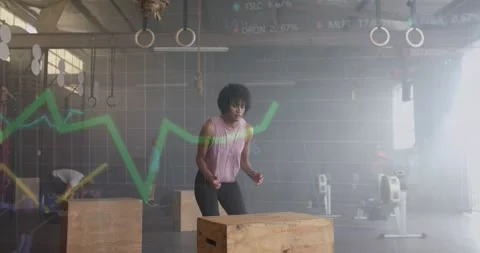 Animation of graph processing over woman jumping on box cross training at gym Stock Footage 328635045