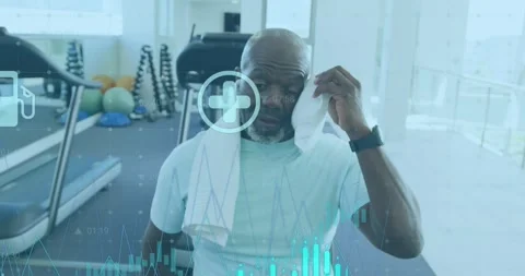 Animation of graphs and icons over tired african american man wiping head with Stock Footage 252965763