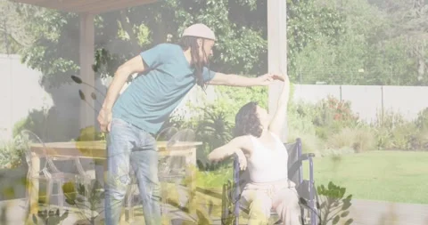 Animation of grass over man and disabled woman sitting in wheelchair Stock Footage 328969574