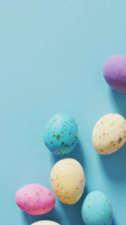 Animation of hand with easter decorations and easter eggs over blue background Stock Footage 341918365