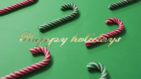 Animation of happy holidays text over candy canes on green background Stock Footage 309600602