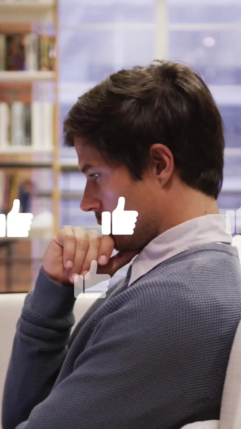 Animation of like icons floating against thoughtful man using laptop at office Stock Footage 344679799