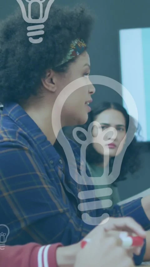 Animation of light bulb icons over diverse business people working in office Stock Footage 344525267