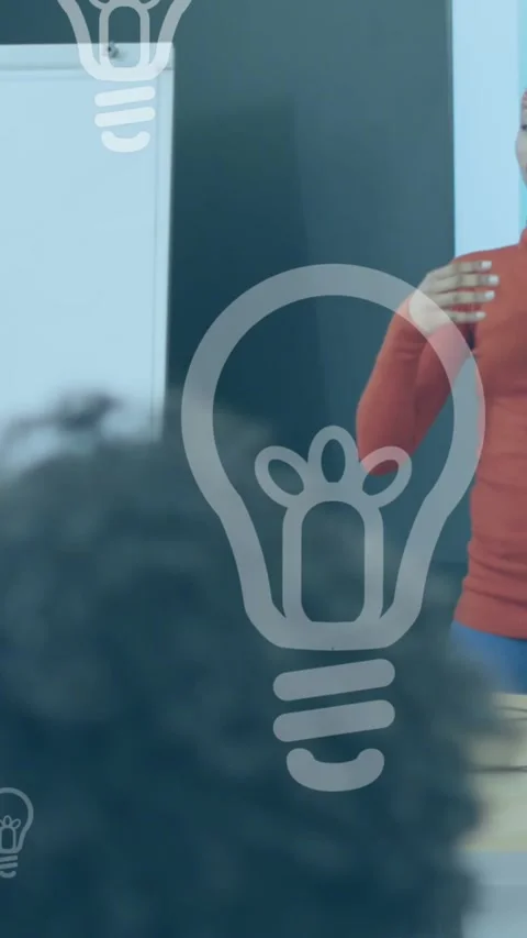 Animation of light bulb icons over diverse business people working in office Stock Footage 344595072