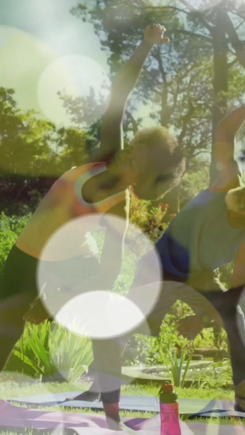 Animation of light spots over african american couple doing yoga, stretching, Vídeo Stock 342802169