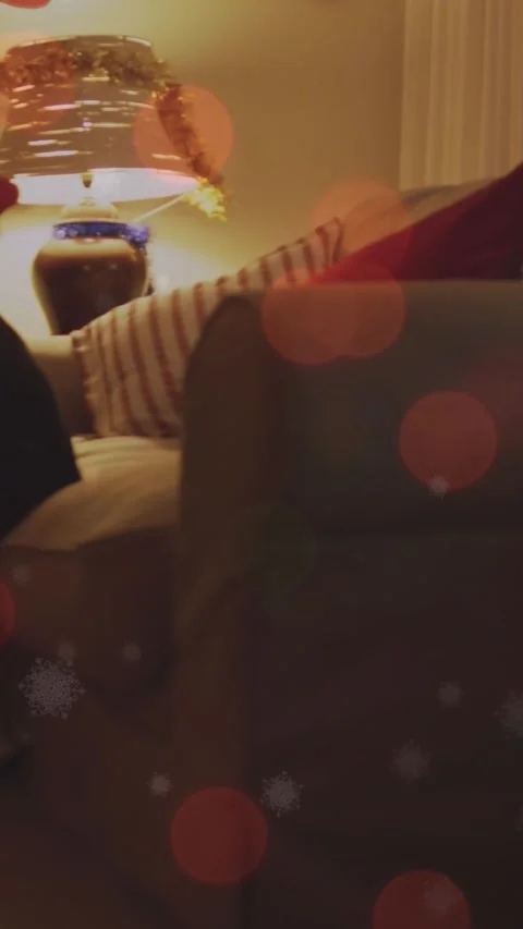 Animation of light spots over caucasian couple in santa hats playing guitar and Vídeo Stock 343497558