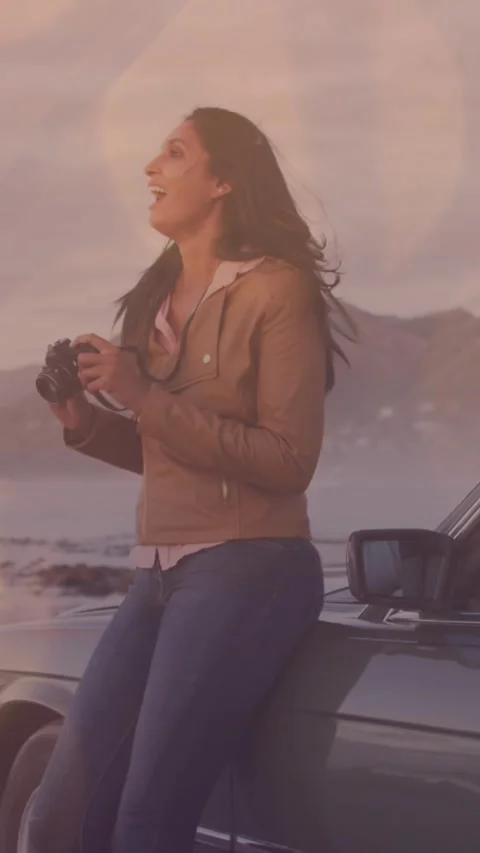 Animation of light spots over happy diverse couple taking photo with car Vídeo Stock 342315956
