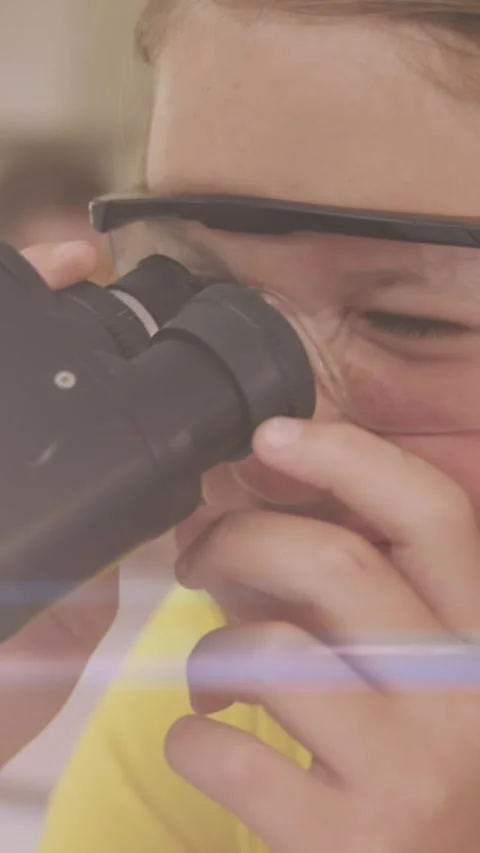 Animation of light trails over caucasian schoolgirl using microscope Stock Footage 322559895