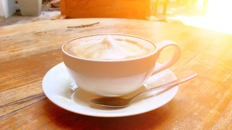 Animation looping coffee cup Cappuccino on wood table with orange light Stock Footage 98810941