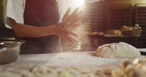 Animation of midsection of male baker clapping hands to clean flour at bakery Stock Footage 341392689