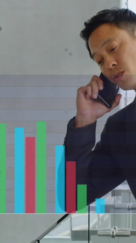 Animation of multicolored bar graphs over asian man talking on cellphone in Stock Footage 344746072