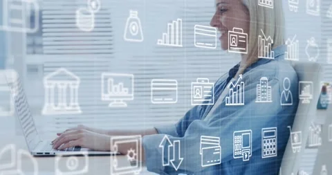 Animation of multiple icons over caucasian woman working on laptop in office Stock Footage 237494848