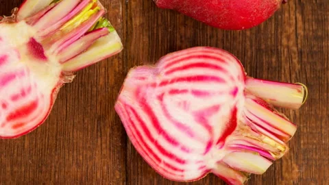 Animation of multiple red beetroots on wooden background Stock Footage 312472817