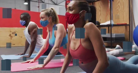 Animation of notebook icons over diverse people wearing face masks and Stock Footage 329414242